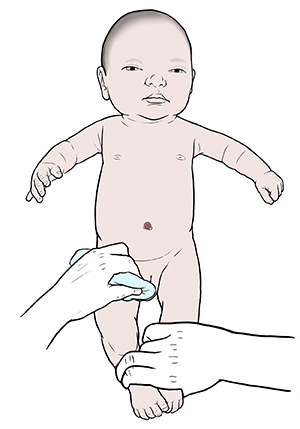 One hand holding newborn baby boy securely on diaper-changing pad and other hand cleaning baby's penis.